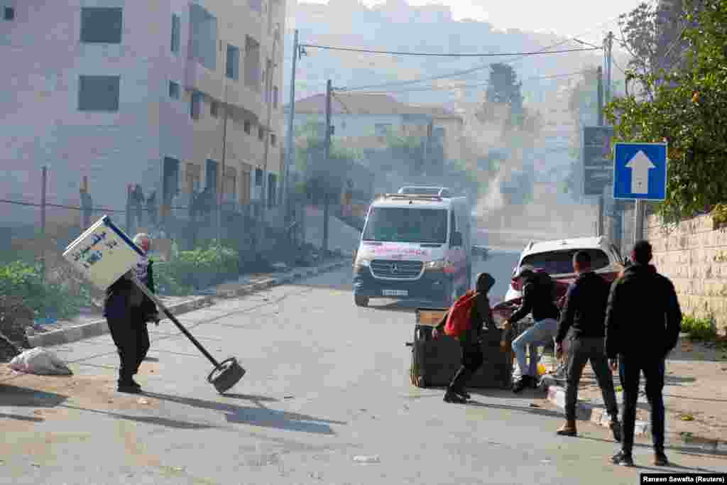 Palestinezët duke reaguar teksa një autoambulancë lëvizte mes përleshjeve me trupat izraelite.