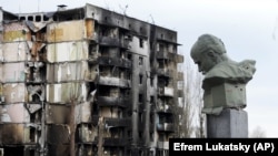Пам'ятник Шевченка з простреленою головою на тлі зруйнованого російською армією будинку у Бородянці. 6 квітня 2022 року 