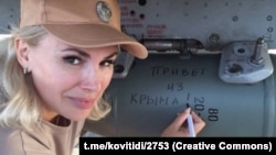 Российский сенатор из Крыма Ольга Ковитиди подписывает авиационную ракету, которая предназначена для нанесения удара по гражданскому населению Украины, 26 января 2023 года