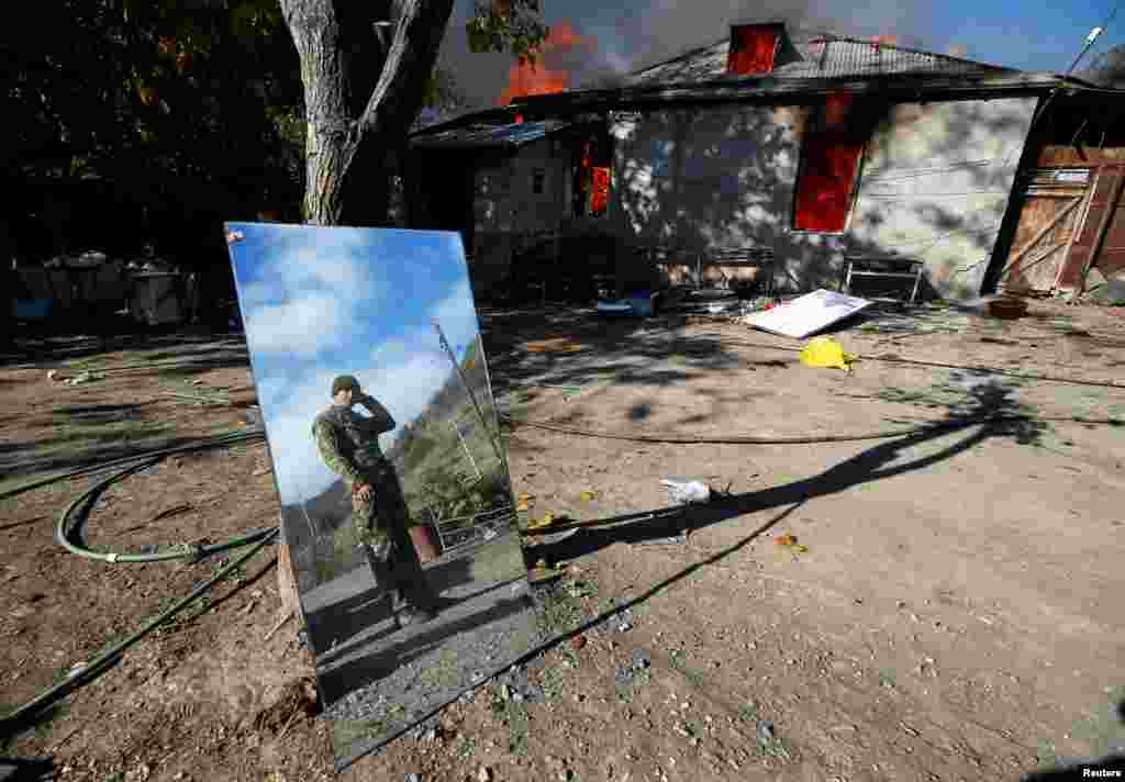 A man is reflected in a mirror near a house set on fire by departing ethnic Armenians in the village of Cherektar in Nagorno-Karabakh on November 14, 2020. Under the terms of the agreement, Armenians had to vacate certain parts of Nagorno-Karabakh. &nbsp;