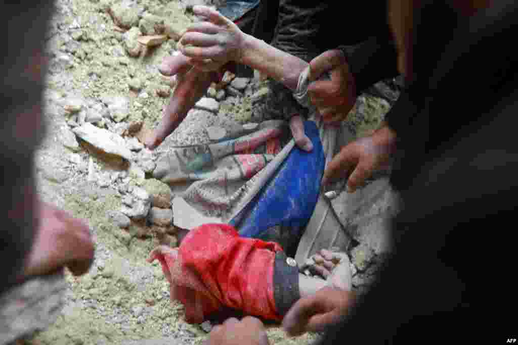Сирійські рятувальники намагаються дістати жертву з-під уламків будівлі в місті Хама після землетрусу 6 лютого 2023 року. Фото від 7 лютого 2023 року