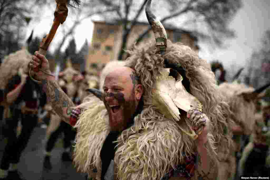 A man dressed in animal fur yells out to scare away evil spirits as he performs a dance.