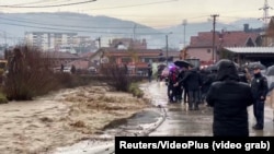 People stand by the river in Novi Pazar, Serbia, on January 19.