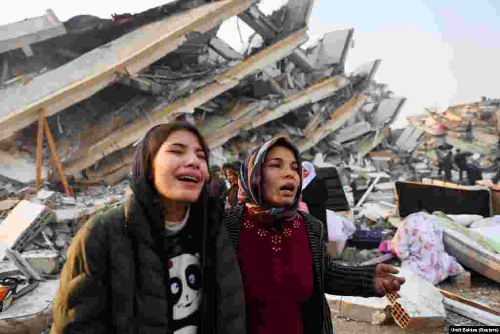 Două femei plâng lângă dărâmături în urma unui cutremur din Hatay, Turcia, 7 februarie 2023. REUTERS/Umit Bektas.