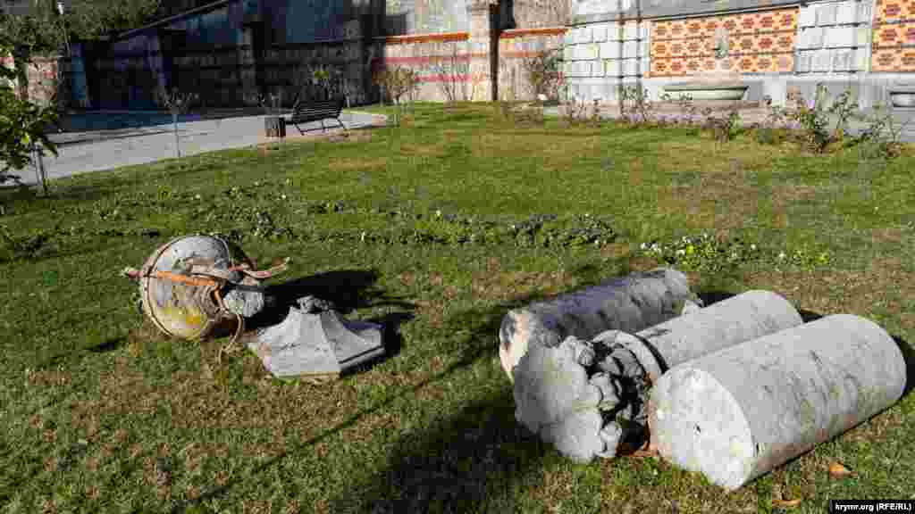 Stone column fragments and a vase litter the grounds.&nbsp;