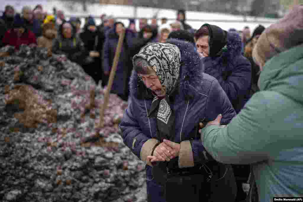 Relatives react at the grave of a Ukrainian servicemen who was killed at the eastern front, during his funeral in Lviv.&nbsp;