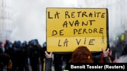 Një protestuese në Paris kundër planit qeveritar për pensione mban një pankartë ku shkruan "Pensionim para vdekjes". Francë, 21 janar 2023.