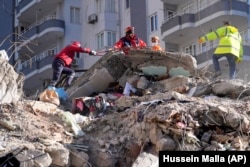 Спасательные бригады ищут людей среди обломков разрушенного здания в городе Адана на юге Турции. 7 февраля 2023 года.