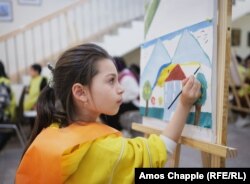 Eight-year-old Angelina paints the Goris hotel where she has stayed with her mother and sister since shortly after the blockade began. The girl made the painting at an art class arranged for Karabakh children at a gallery in Goris on February 9.