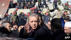 Президент Реджеп Тайип Эрдоган осматривает разрушенные здания во время визита в город Кахраманмараш на юго-востоке Турции.