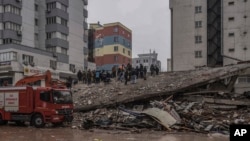 Хора и аварийни екипи търсят хора в развалините на разрушена сграда в Газиантеп, Турция, понеделник, 6 февруари 2023 г.