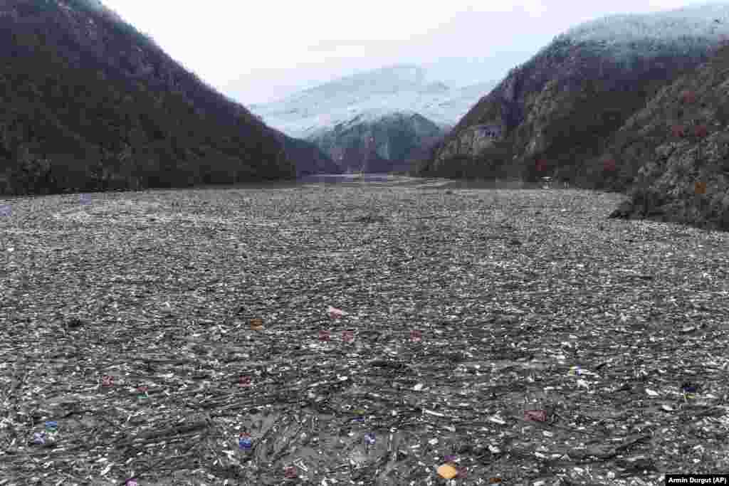Мусор плавает в реке Дрина недалеко от Вишеграда. Босния, 20 января 2023 года. Тонны отходов, сбрасываемых на плохо регулируемые прибрежные свалки или непосредственно в реки в трех странах Западных Балкан, в конечном итоге накапливаются в период паводка зимой и весной. Под мусором барьер на реке Дрина в восточной Боснии.&nbsp;(AP Photo/Armin Durgut)&nbsp;