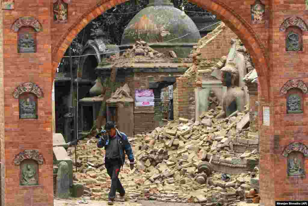 Непальский мужчина плачет, прогуливаясь по руинам после землетрясения в Бхактапуре, недалеко от Катманду, Непал, 26 апреля 2015 года. Землетрясение магнитудой 7,8, произошедшее 25 апреля 2015 г., унесло жизни более 8800 человек.