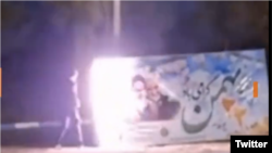 A protester sets fire to a government banner in Isfahan.