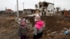 Діти стоять біля воронки, утвореної російським ракетним ударом, під час атаки Росії на Україну, у місті Глеваха, під Києвом, 26 січня 2023 року