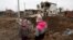 UKRAINE – Kids stand next to a crater left by a Russian missile strike, amid Russia's attack on Ukraine, in the town of Hlevakha, outside Kyiv, January 26, 2023