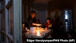 Nagorno-Karabakh - A woman and her son have a dinner at their home in Stepanakert in the absence of electricity and gas, January 18, 2023.