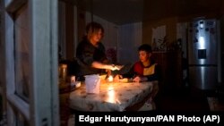 Nagorno-Karabakh - A woman and her son have a dinner at their home in Stepanakert, during a power blackout, January 18, 2023.