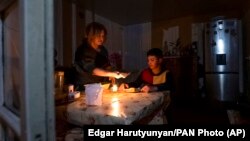 Nagorno-Karabakh - A woman and her son have a dinner at their home in Stepanakert amid a power blackout, January 18, 2023.