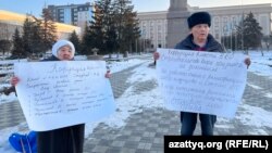 Пенсионеры Баян и Искак Азбергеневы с плакатами на акции протеста. Уральск, 30 января 2023 года