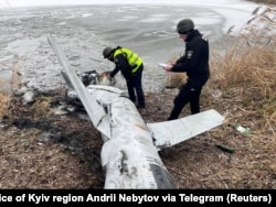 Украинские полицейские обследуют российскую крылатую ракету, сбитую под Киевом, 26 января 2023 года