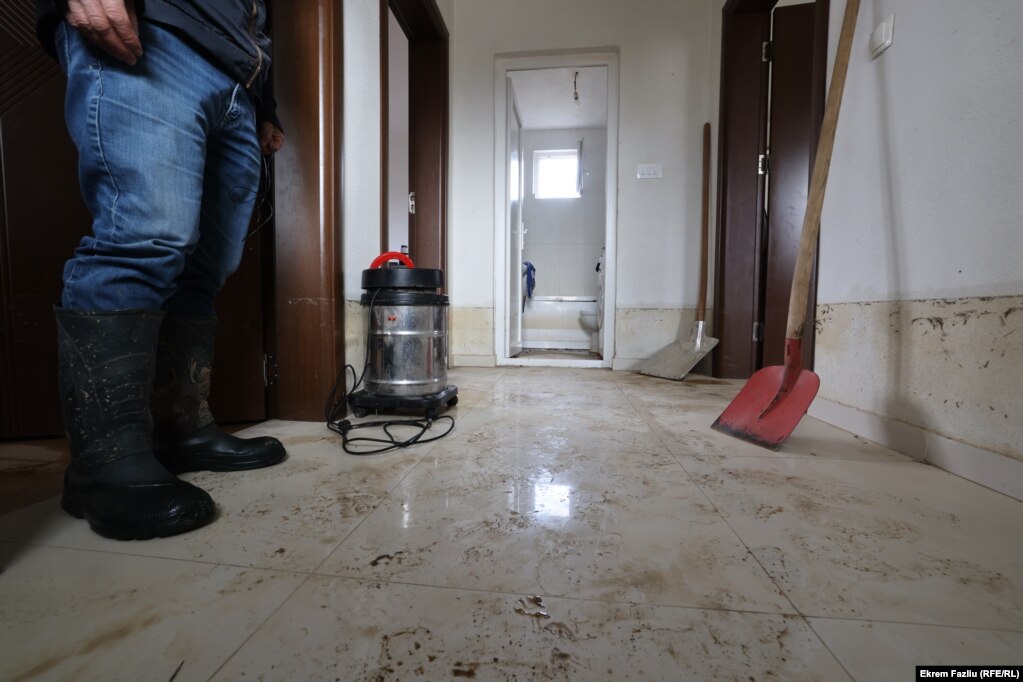 Një banor duke pastruar shtëpinë e tij, pas vërshimeve, në Llaushë.