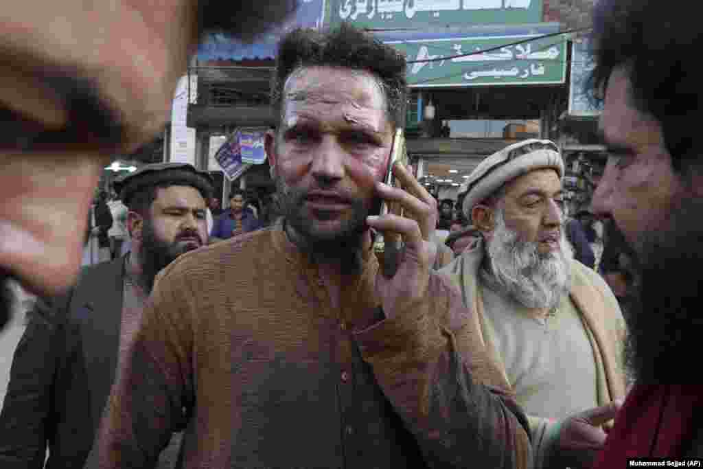 În fața unui spital din Pashawar, unul dintre cei răniți vorbește la telefon după ce a fost tratat. Incidentul are loc la aproape un an după ce un alt atentat sinucigaș cu bombă a ucis 63 de persoane într-o moschee șiită din Peshawar. &nbsp;