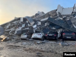 Автомобили под обрушившимся зданием после землетрясения в провинции Хатай. Турция, 7 февраля 2023 года