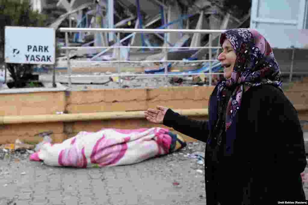 O femeie plânge lângă cadavrul unei rude, în timp ce căutarea supraviețuitorilor continuă, în urma unui cutremur în Hatay.