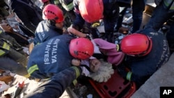 Echipe de salvare evacuează un supraviețuitor de sub dărâmăturile unei clădiri distruse în Kahramanmaras, în sudul Turciei, marți, 7 februarie 2023