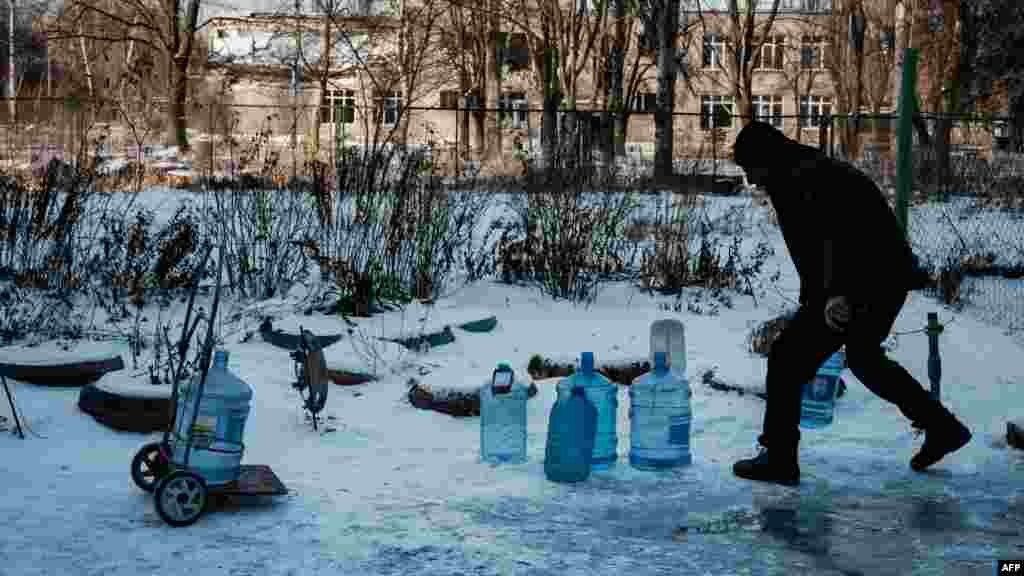 Az 51 éves Andrej víztartályokat pakol, hogy hazahordja őket egy vízvételi pontról