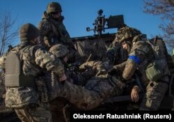 Sebesült ukrán katonát evakuálnak bajtársai a donyecki frontvonalon, Bahmut közelében 2023. január 23-án