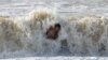 A believer dips into a wave during a ceremony marking the Orthodox Christian feast of Epiphany in the Black Sea resort city of Saky, Crimea.