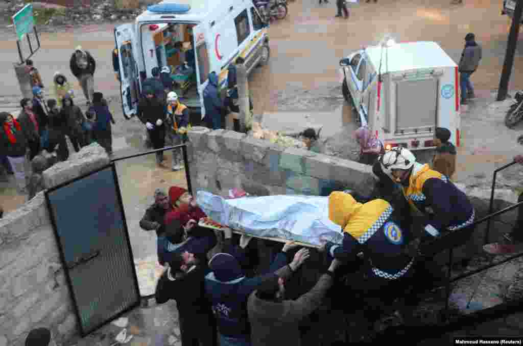 Спасатели несут тело пострадавшего на месте поврежденного здания после землетрясения в удерживаемом повстанцами Азазе, Сирия, 6 февраля 2023 года