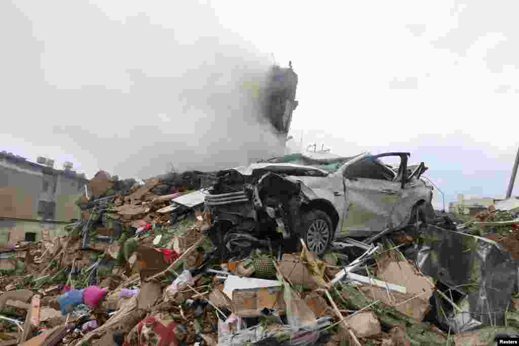 Поврежденный автомобиль на обломках после землетрясения в Искендеруне, Турция, 6 февраля 2023 года