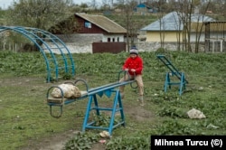 O fetiță se joacă singură într-un loc de joacă dintr-un sat din județul Tulcea, în 2010.
