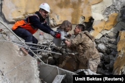 Пятилетнего Мухаммета Рузгара спасатели вытаскивают из разрушенного здания после землетрясения в Хатае, Турция, 7 февраля 2023 года