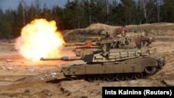 Армейский танк M1A1 Abrams ведет огонь во время военных учений НАТО в Латвии, 26 марта 2021 года. Иллюстрационное фото