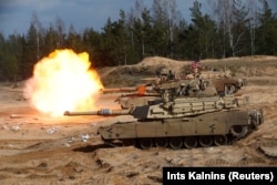 Танк M1A1 Abrams армии США ведет огонь во время учений боевой группы расширенного передового присутствия НАТО «Хрустальная стрела 2021» в Адажи, Латвия, 26 марта 2021 года