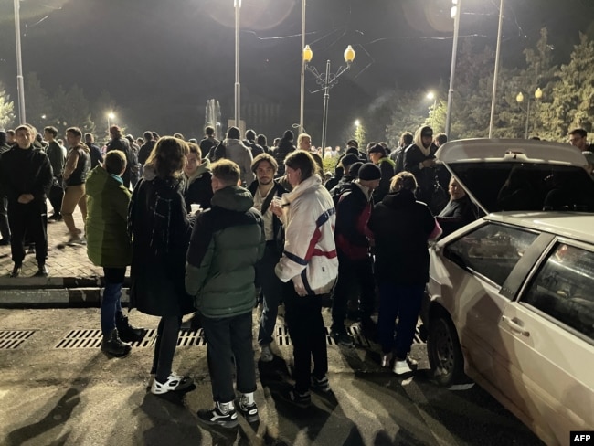 Russian émigrés fleeing mobilization stand outside a railway station in Oral in September 2022.