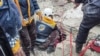 Salvatori sirieni caută persoane prinse sub dărâmăturile unei clădiri distruse din Afrin, Siria. 
