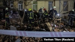 Рятувальники працюють на місці, де багатоквартирний будинок був пошкоджений внаслідок російського ракетного удару у Харкові, 30 січня 2023 року