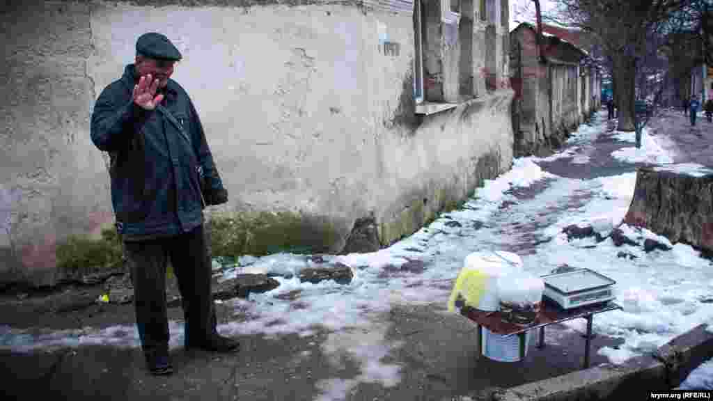 Чоловік продає рибу прямо на перехресті двох вулиць