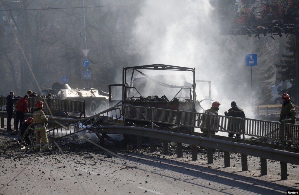 Zjarrfikësit, ekipet e ndihmës së parë dhe ushtarët dalin në vendin e ngjarjes, pasi një makinë është dëmtuar gjatë luftimeve me trupat ruse në Kiev më 26 shkurt.   
