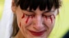 A woman with fake blood on her face reacts during a demonstration staged by supporters of Ukraine outside the Russian Embassy in Mexico City on February 26.