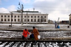 Ljudi koji bježe od ruske invazije na Ukrajinu, prelaze željezničke pruge kako bi došli do voza koji kreće za Poljsku, na željezničkoj stanici u Lavovu, Ukrajina, 28. februar