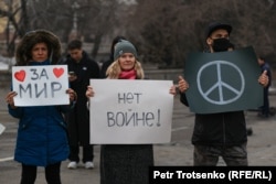 Люди держат антивоенные плакаты на митинге за чистый воздух. Алматы, 26 февраля 2022 года