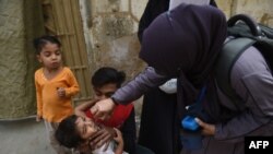 A health worker administers polio vaccine drops to a child during a door-to-door vaccination campaign in Karachi on February 28.
