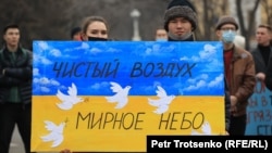 Митинг за чистый воздух в Алматы. Некоторые выражают поддержку Украине. В руках у молодых участников плакат в цветах украинского флага. 26 февраля 2022 года
