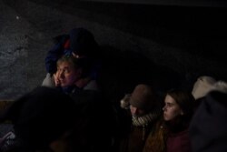 Ljudi čekaju ispod podvožnjaka na željezničkoj stanici u Lavovu kako bi uhvatili voz za Poljsku, u Lavovu, Ukrajina, 28. februar